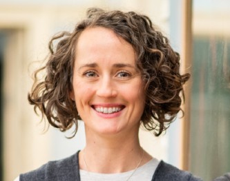 A woman with mousy hair stood in front of a window