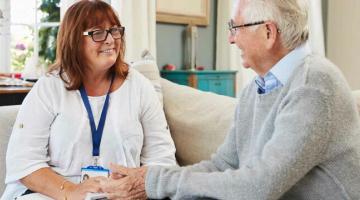 An older man talks to a social care professional 