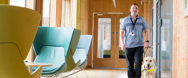 Photo of B&NES employee and his guide dog in Keynsham Civic Centre