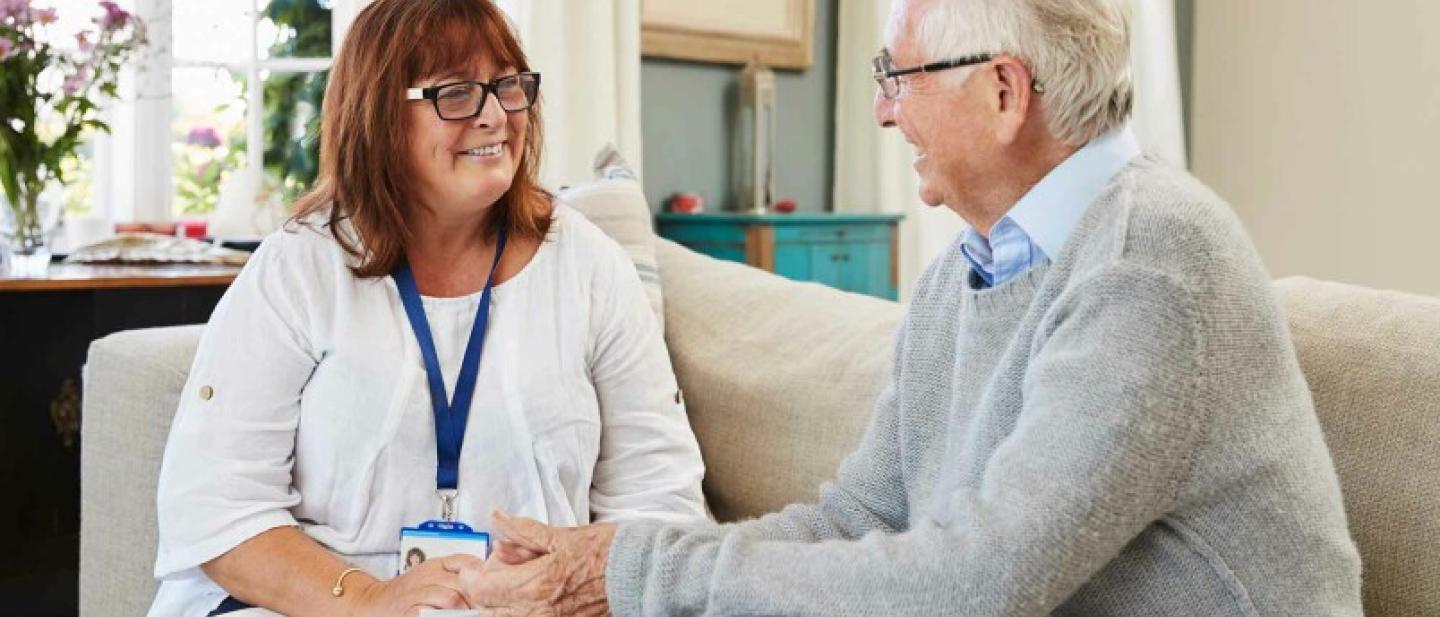 An older man talks to a social care professional 